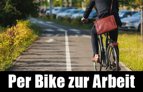 Ein Mann fährt mit dem Fahrrad auf einem Radweg zur Arbeit